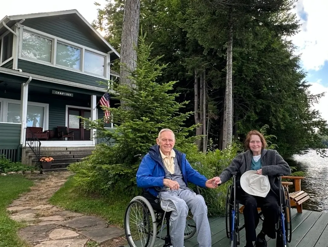 Mom and Dad Wheel Chair in front of the house